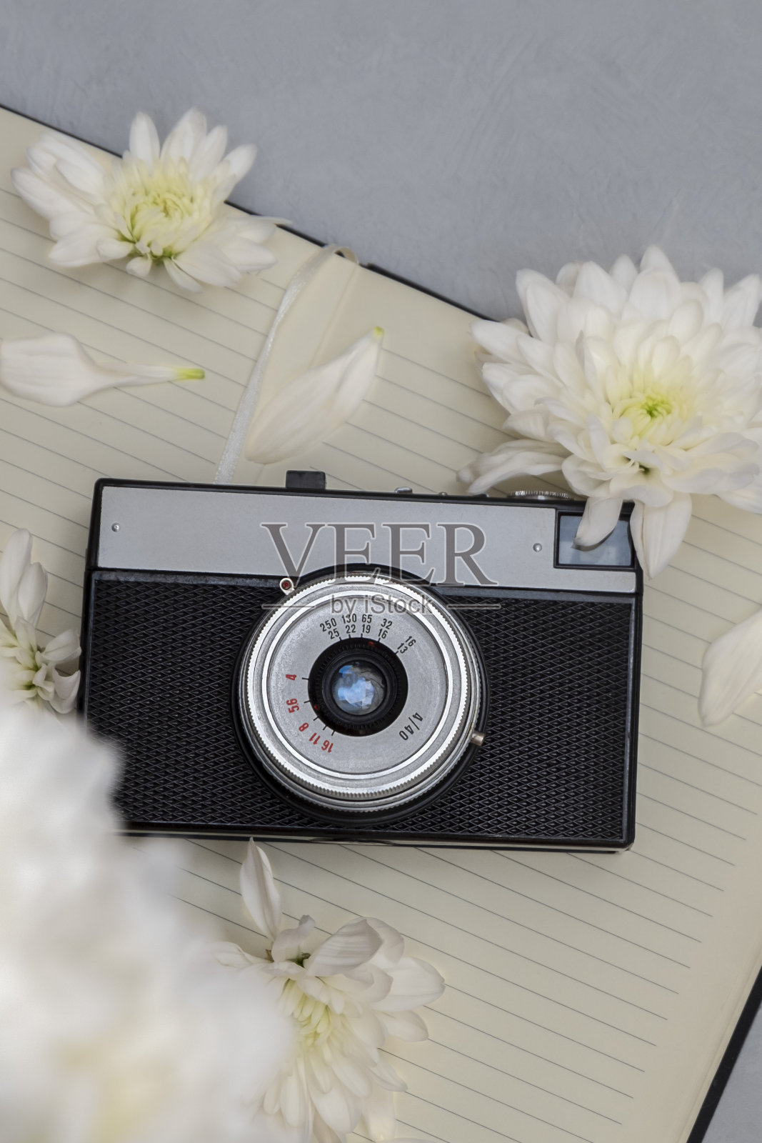 俯视图的复古相机，纸记事本，白色的花。最小平铺风格照片摄影图片