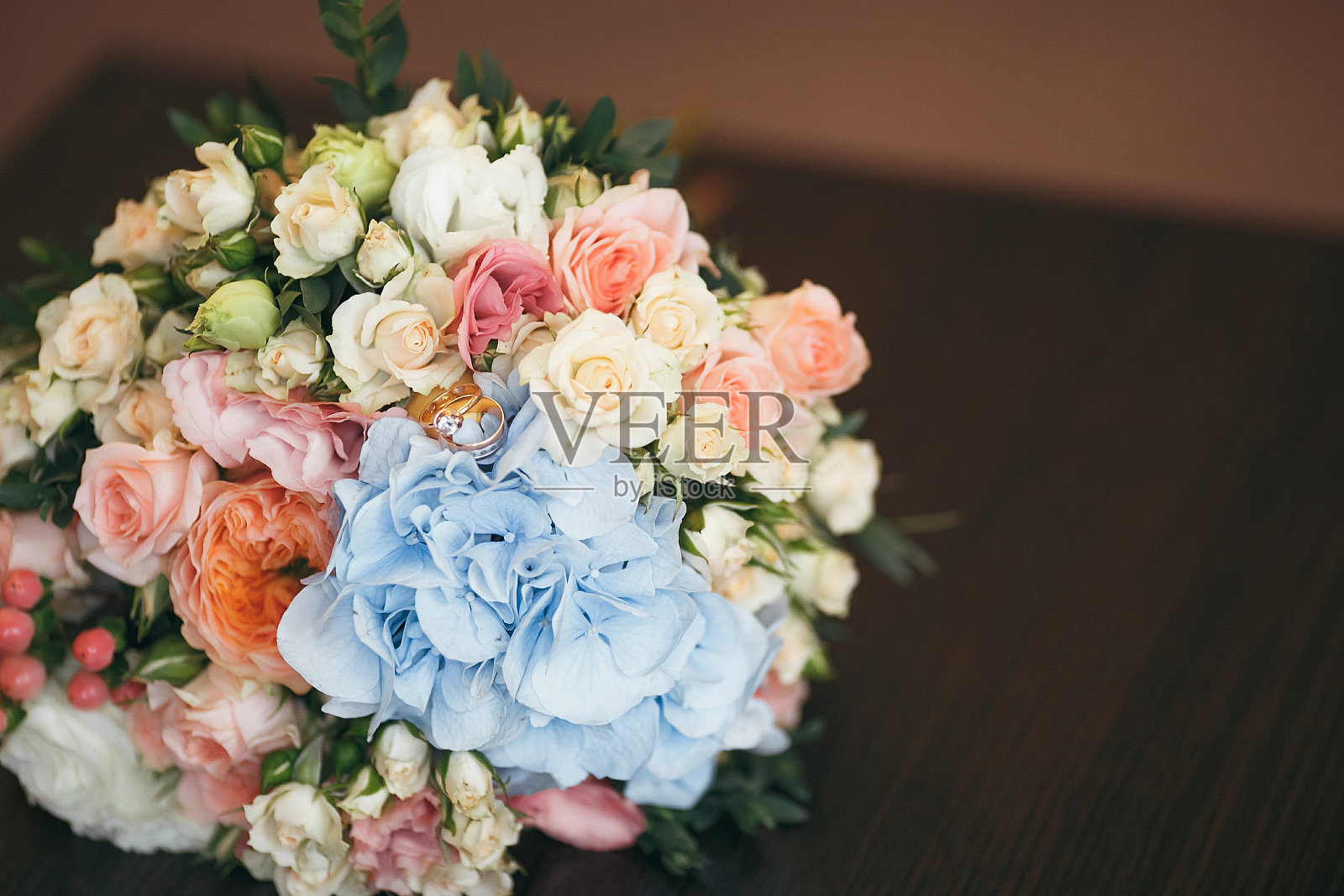 长凳上的新娘花束。婚礼花束由玫瑰和戒指组成照片摄影图片