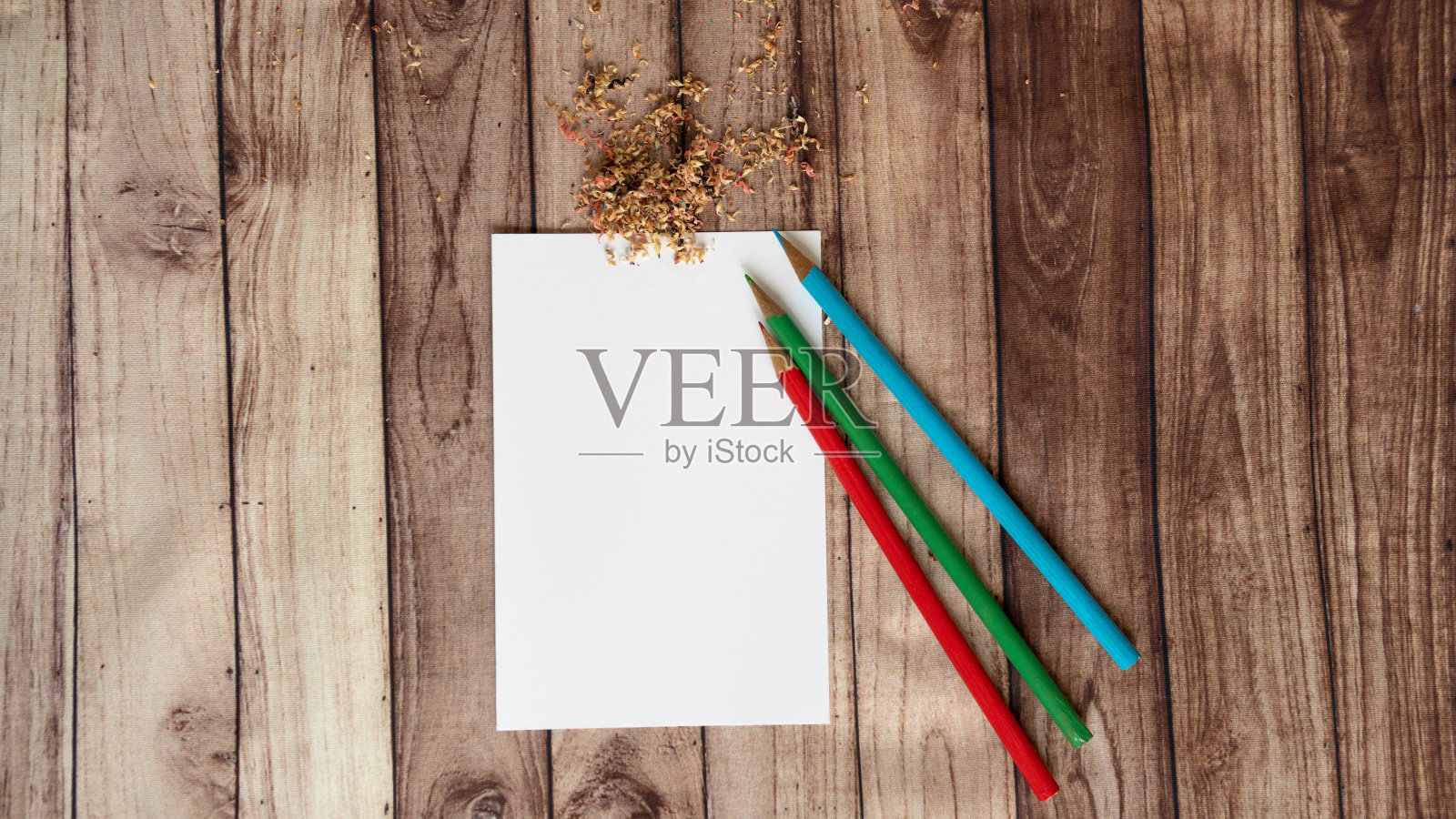 相册页上，三支铅笔在桌子上画画，纸和铅笔红绿蓝照片摄影图片