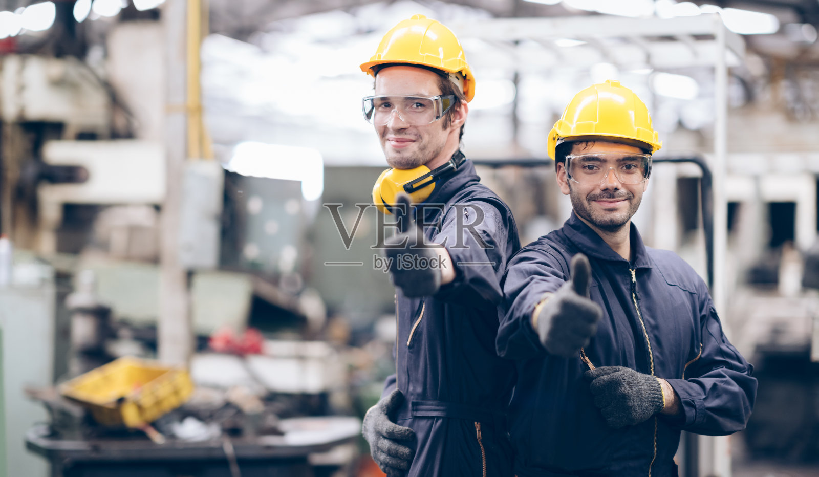 技术人员和合作伙伴在工厂的机器旁竖起摄像头照片摄影图片