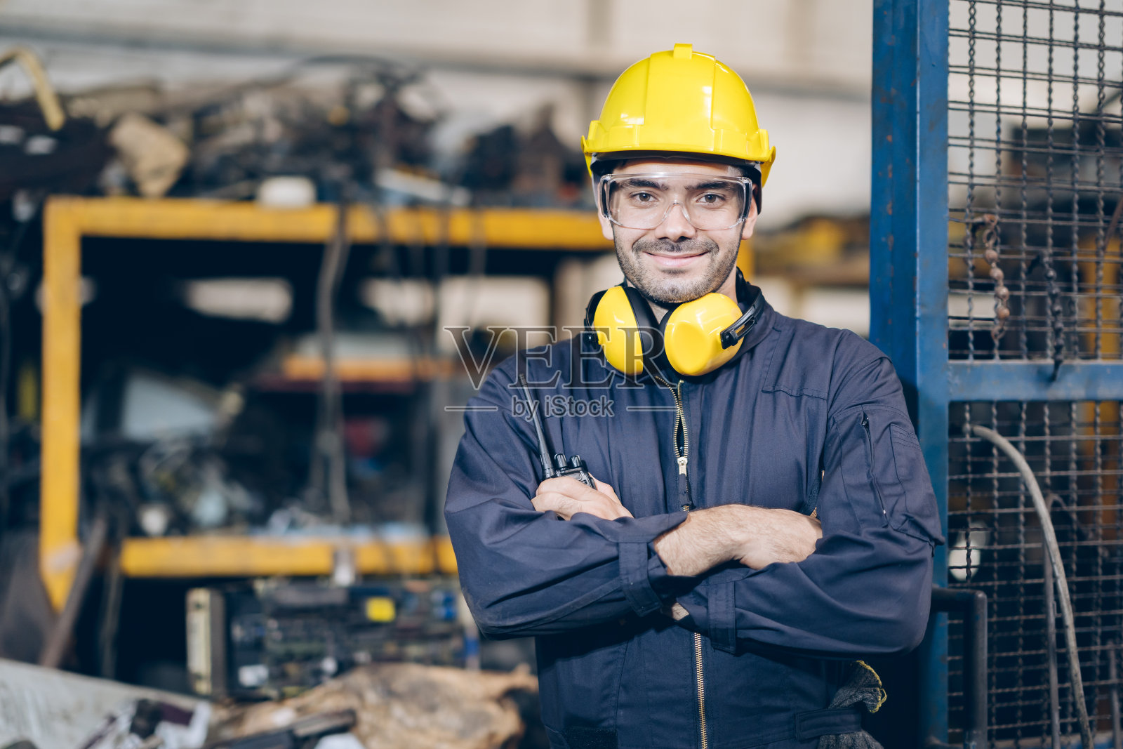 微笑技术员工程师双手交叉，手持便携式收音机在工厂照片摄影图片