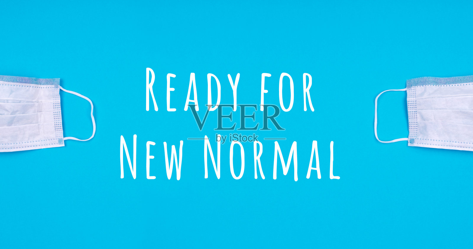 蓝色背景上的两个药罩。冠状病毒大流行减少，走向新常态，经济重新开放的理念照片摄影图片