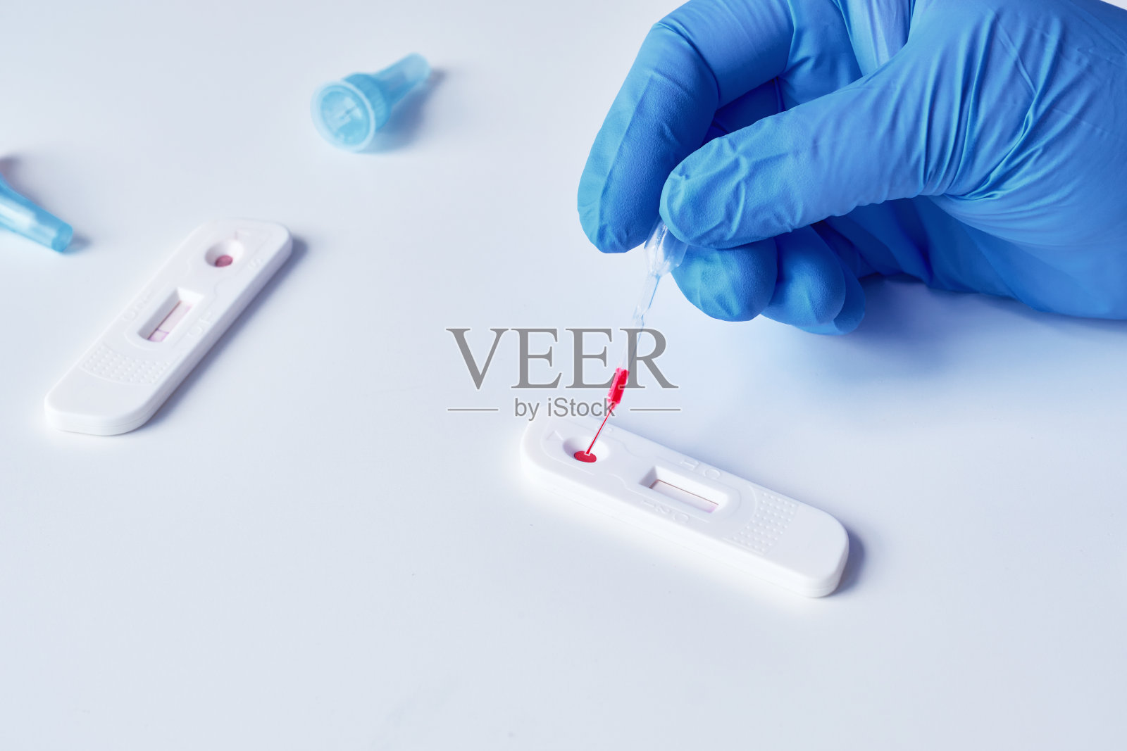 新型冠状病毒SARS-CoV-2特异性抗体IgM和IgG快速检测试剂盒医生或医生用移液管从病人手指上取血。照片摄影图片