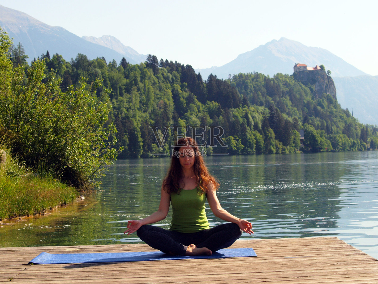 在码头上俯瞰流血湖练习瑜伽的女人照片摄影图片