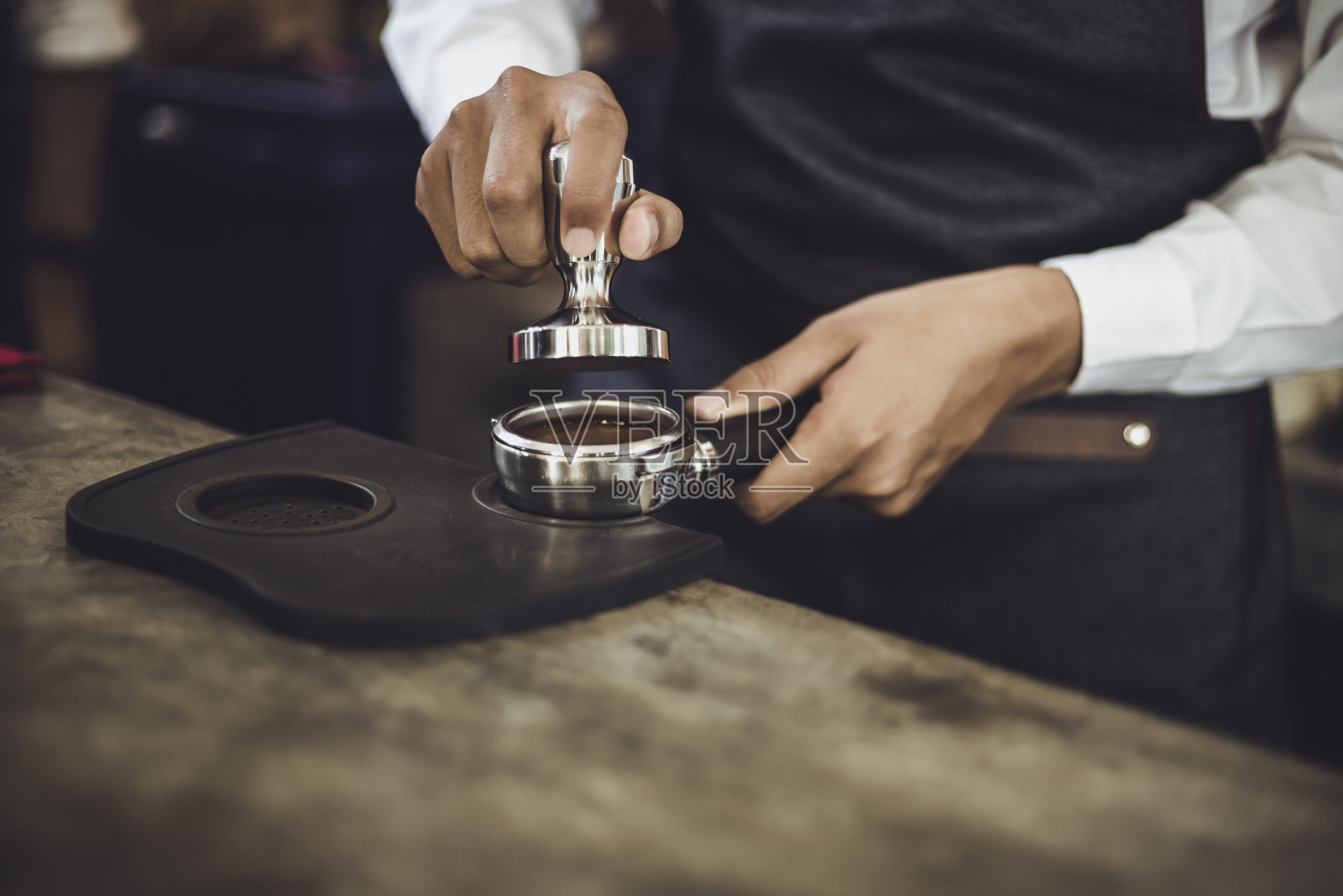 男咖啡师正在为顾客准备咖啡。咖啡馆老板在咖啡馆里为客户服务。照片摄影图片