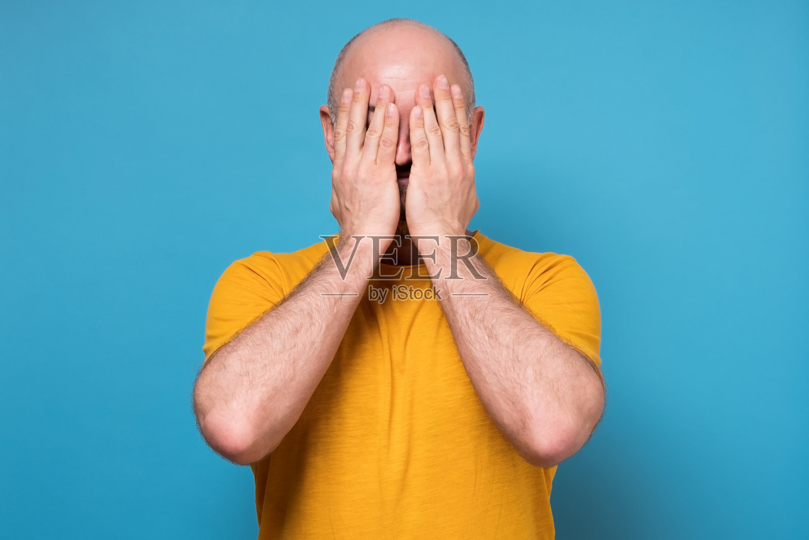 白人成年男子用手捂着脸，感到紧张和孤独照片摄影图片