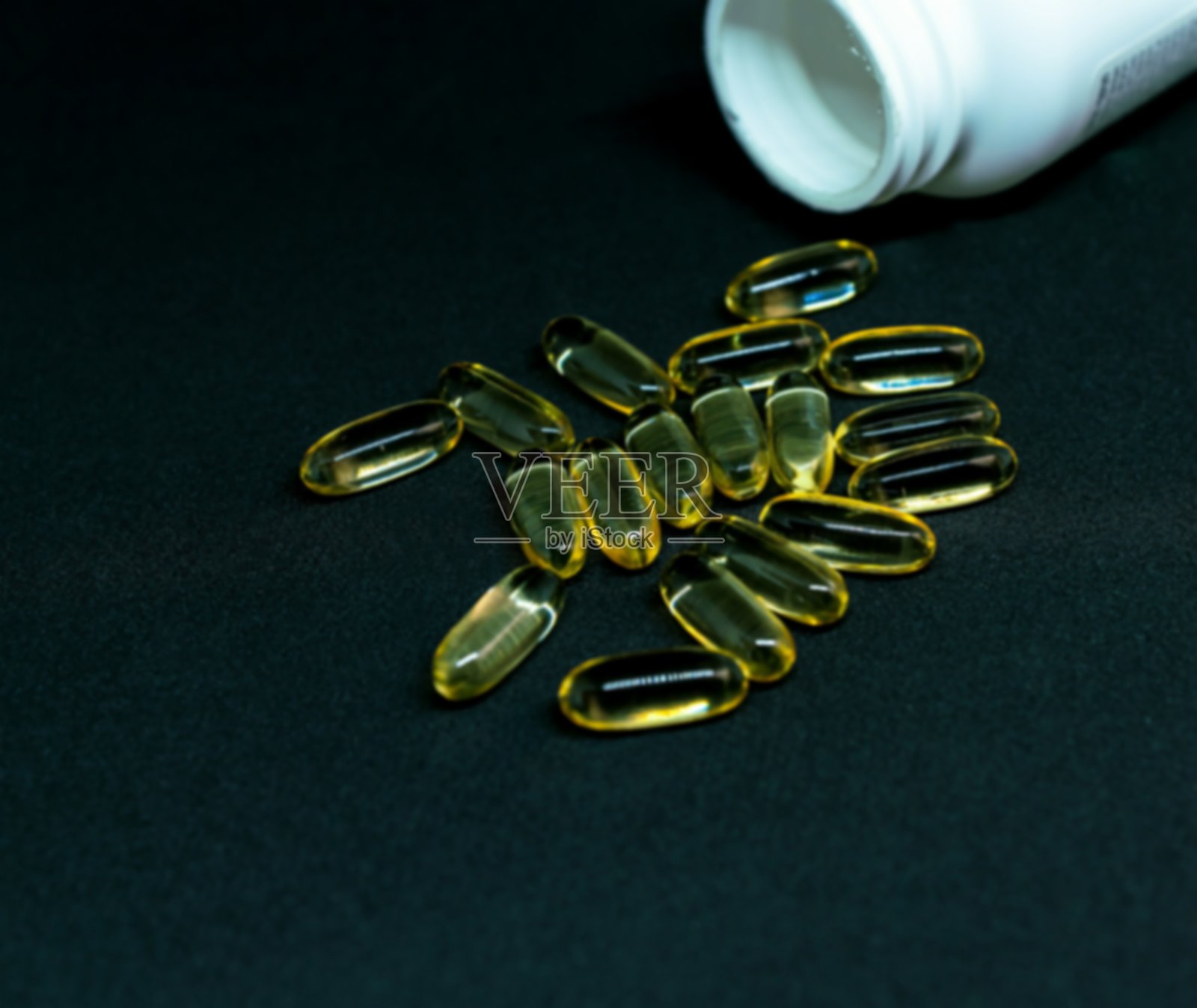 深色背景下的鱼油胶囊和药丸瓶：Omega-3照片摄影图片