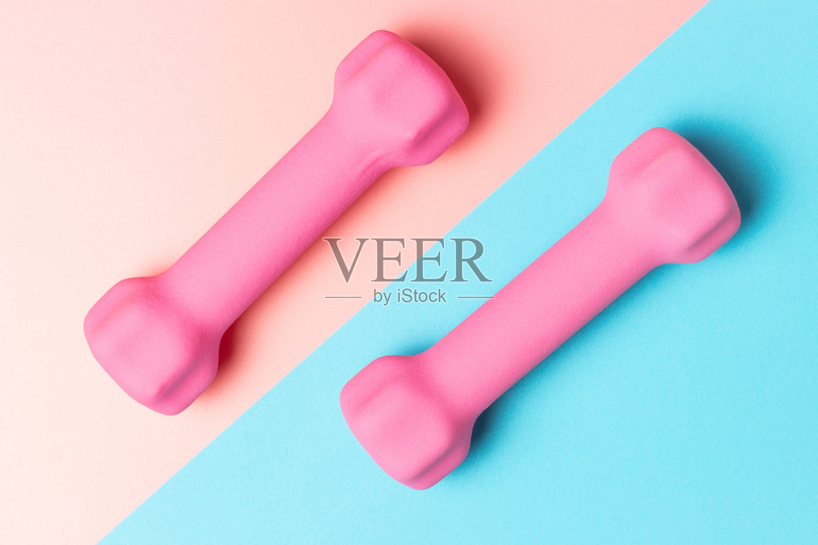 粉色哑铃，粉色和蓝色背景，俯视图，运动背景照片摄影图片