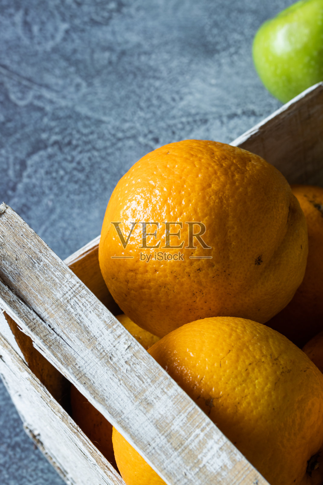 在蓝色背景上的木盒子里的新鲜橙子和柠檬的特写。装运和运送装在木箱里的柑橘。前视图。副本的空间。照片摄影图片