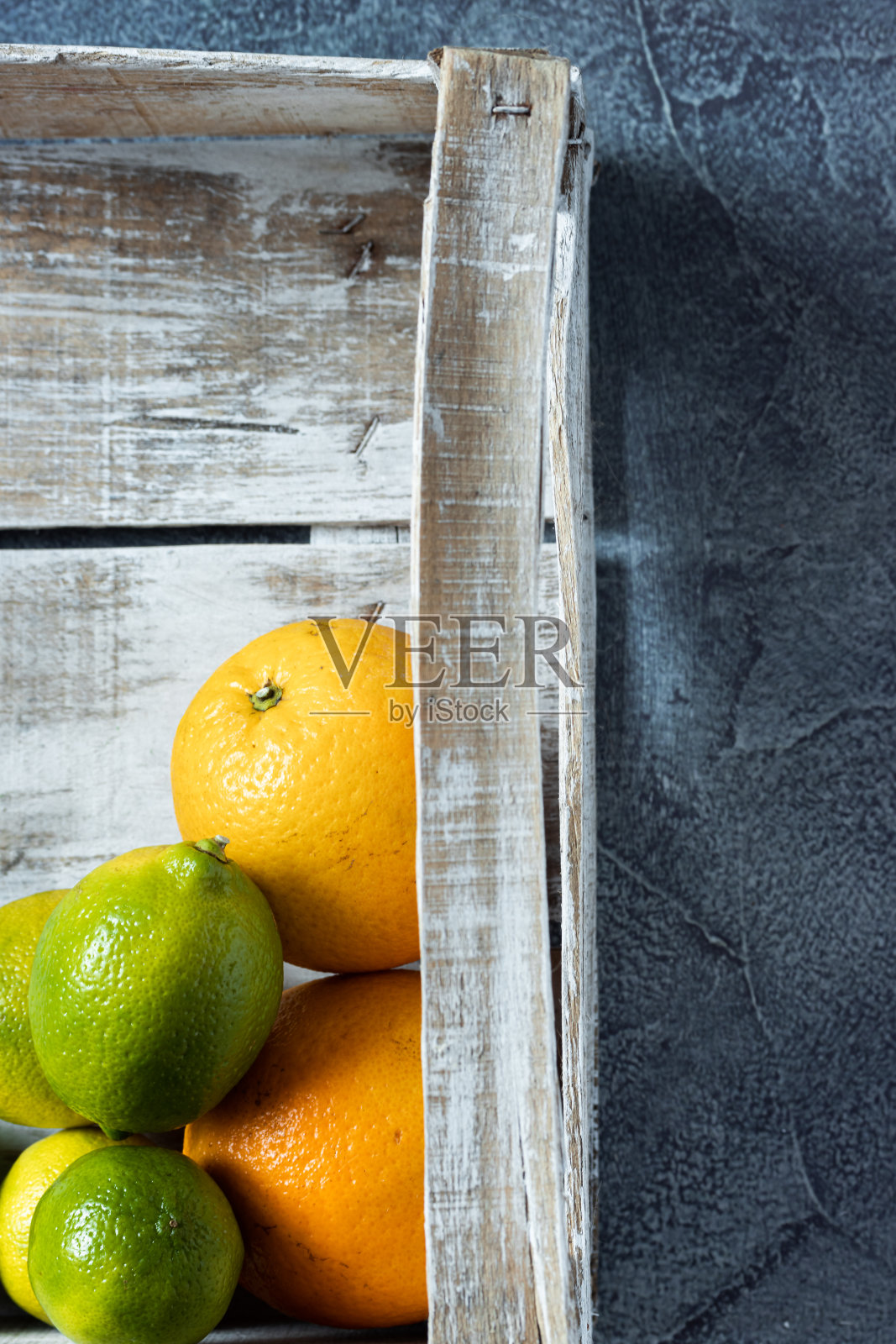 白木背景上的木盒子里的新鲜橙子和柠檬的特写。装运和运送装在木箱里的柑橘。前视图。副本的空间。照片摄影图片