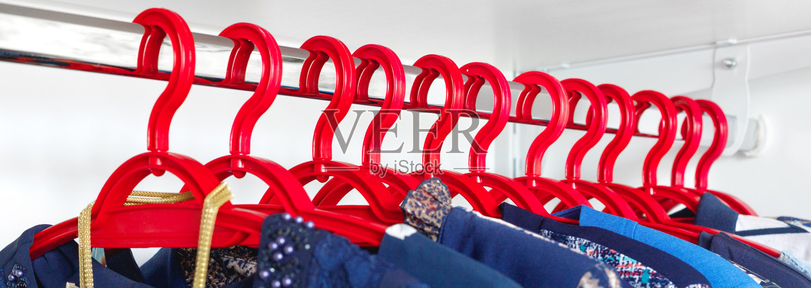 现代衣柜，白色衣柜里挂着一排衣服照片摄影图片