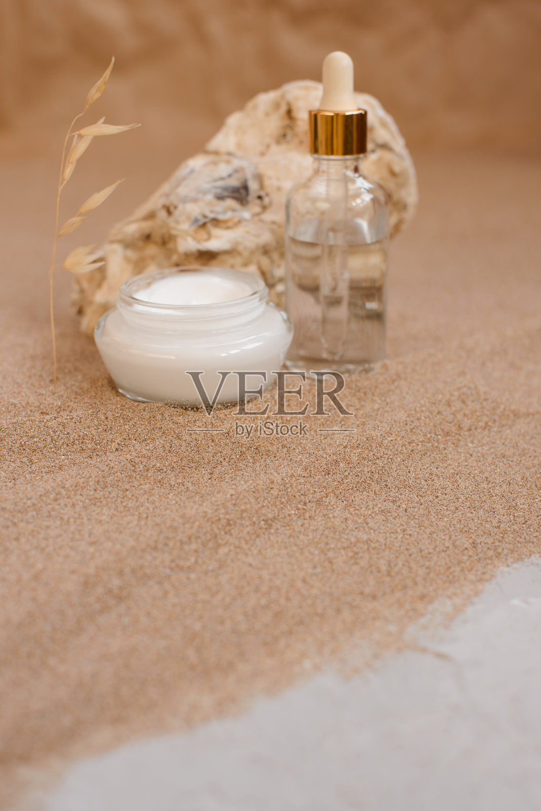 沙滩上的牡蛎壳里装着关怀的化妆品。环保的有机化妆品。照片摄影图片