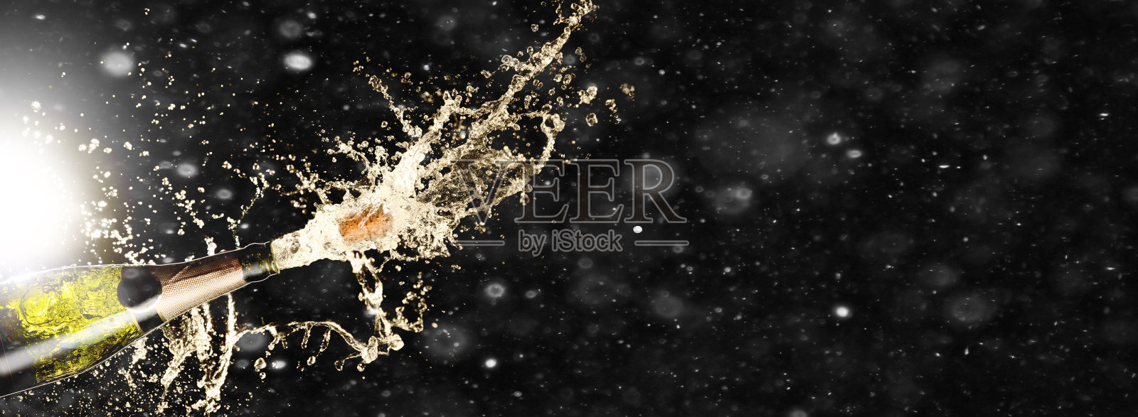 庆祝主题泼洒香槟在黑色背景与雪和自由的空间。圣诞节或新年，情人节的背景。照片摄影图片