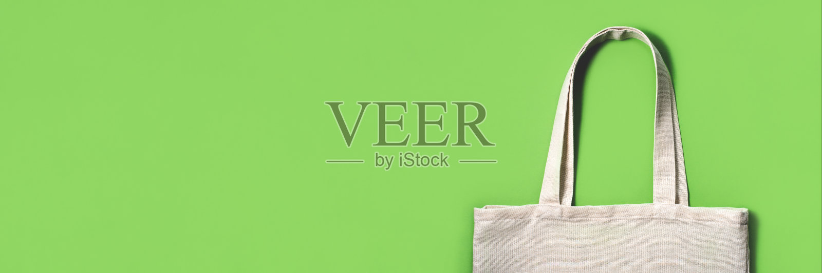 绿色背景的织物环保袋。照片摄影图片