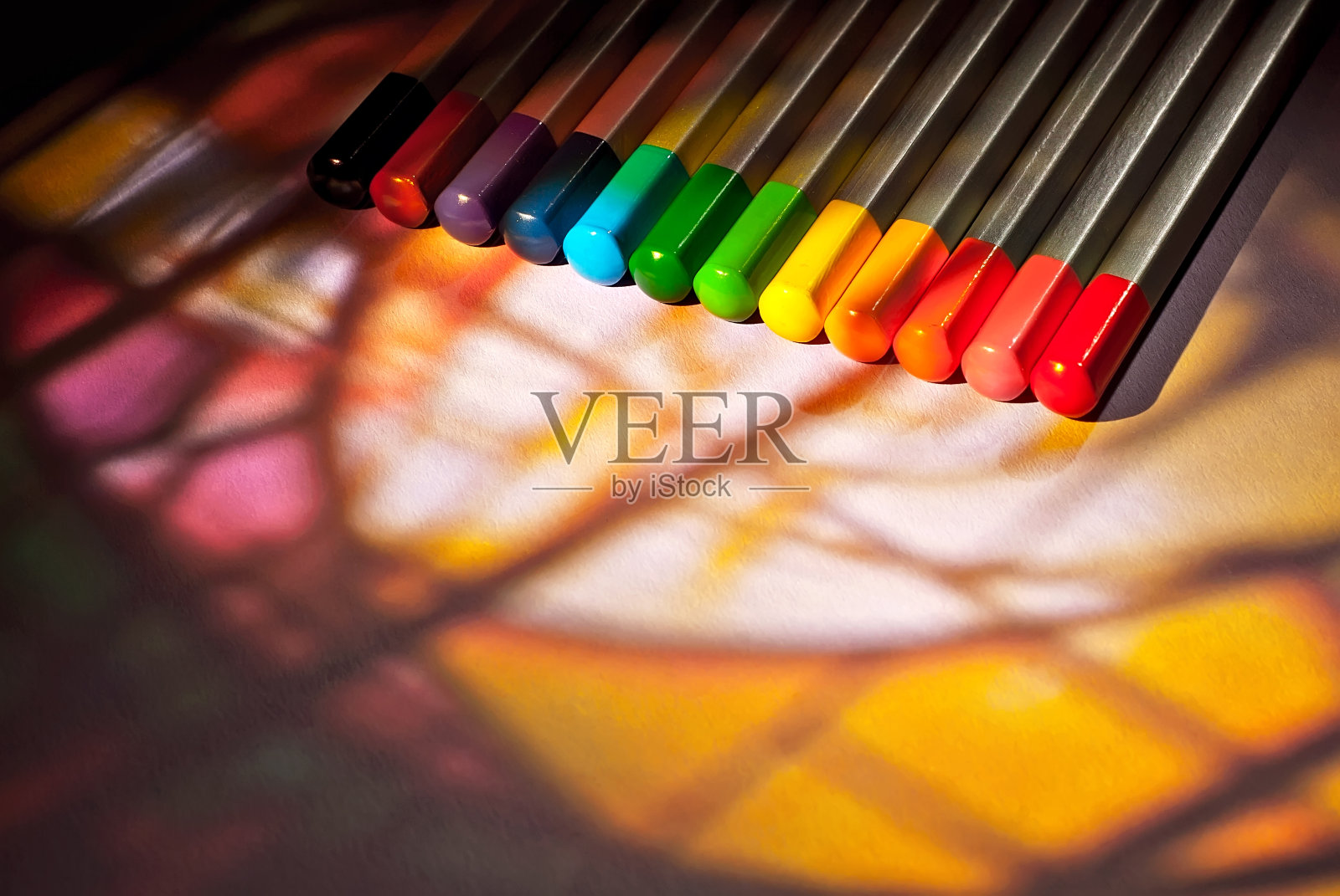 彩色铅笔在纸上的背景接近。大量的铅笔与反差的戏剧性的光线。文本的自由拷贝空间。模型。照片摄影图片