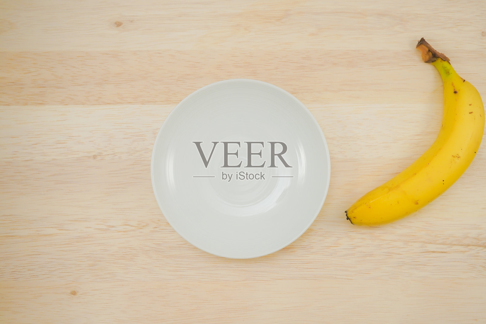 盘子和香蕉放在桌子上照片摄影图片