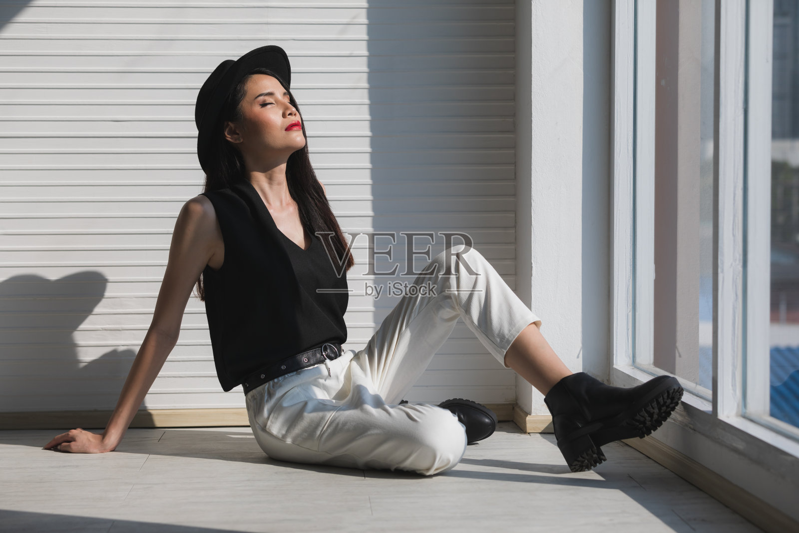 靠窗坐的亚洲妇女。照片摄影图片