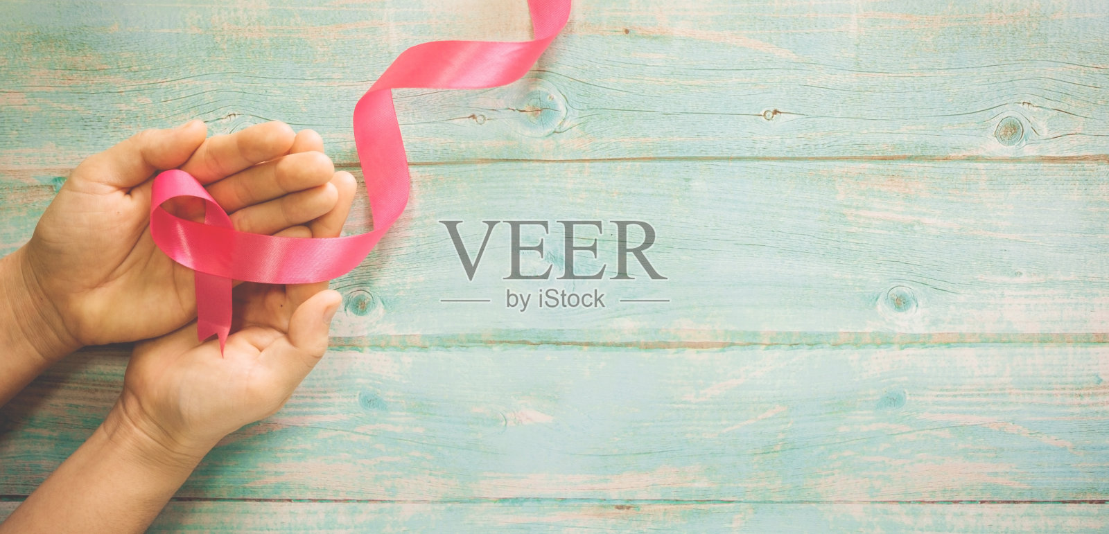 手握粉红丝带。照片摄影图片