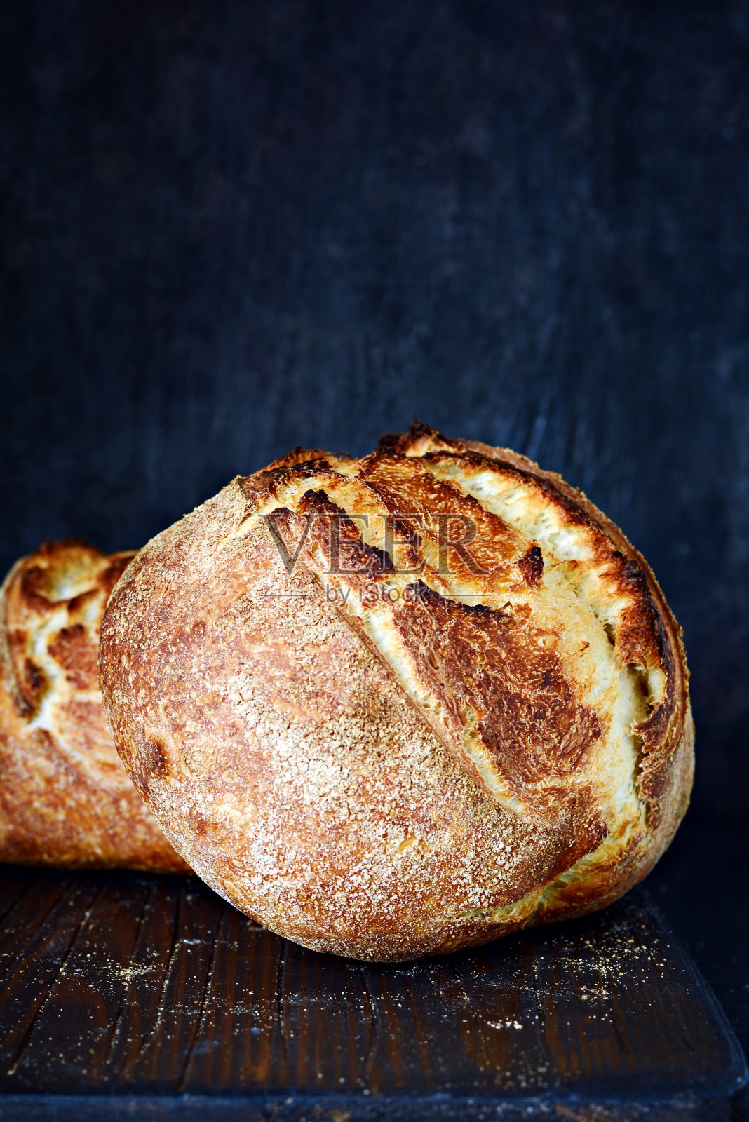 用小麦和全麦面粉制作的家庭自制新鲜烘焙乡村面包。法国新鲜出炉的面包。切片自制的面包照片摄影图片