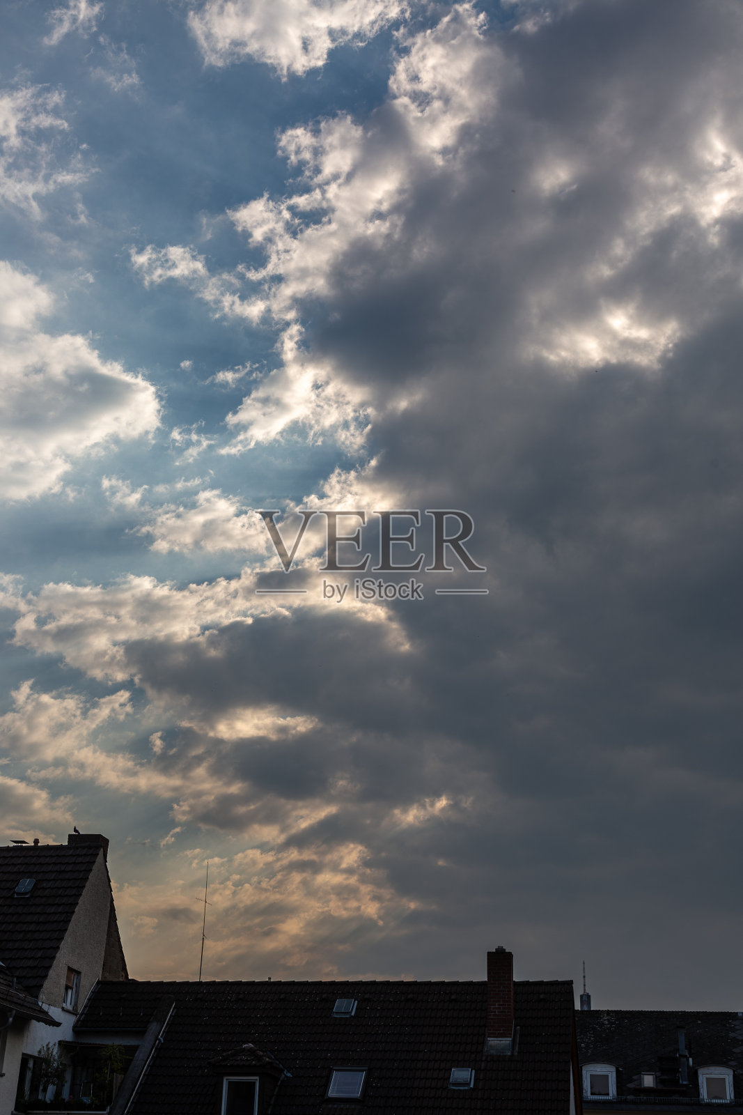 日落与多云戏剧性的天空和屋顶照片摄影图片