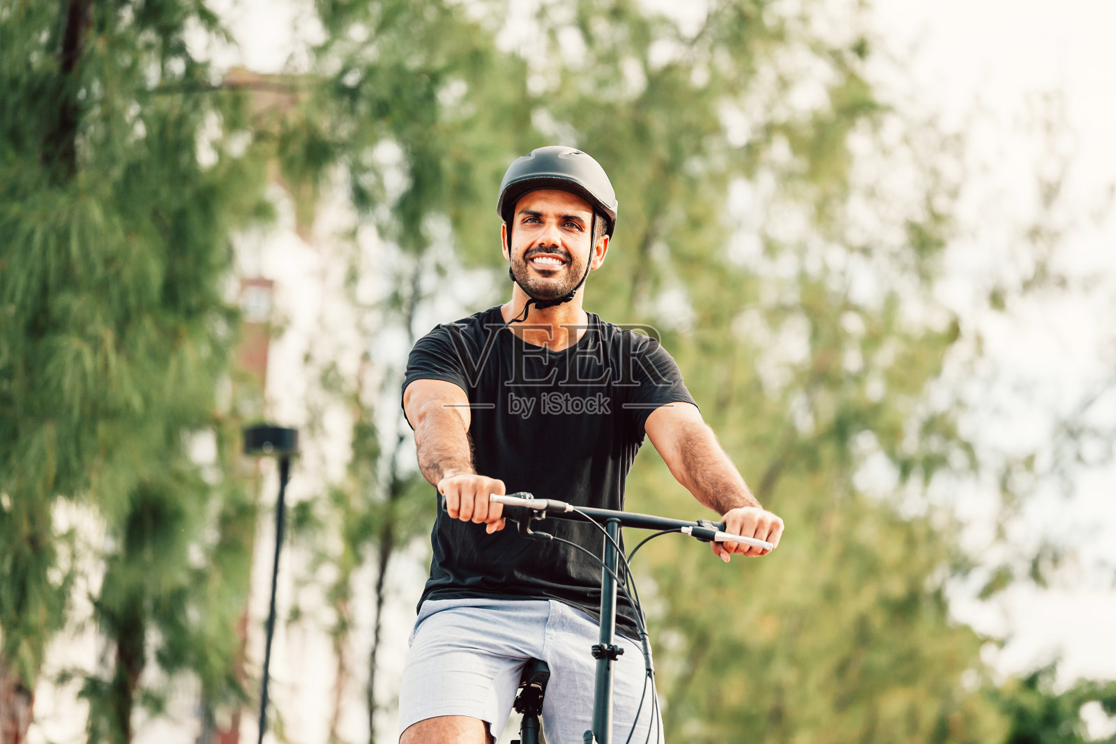 由于社交距离，一个人在公园里骑自行车照片摄影图片