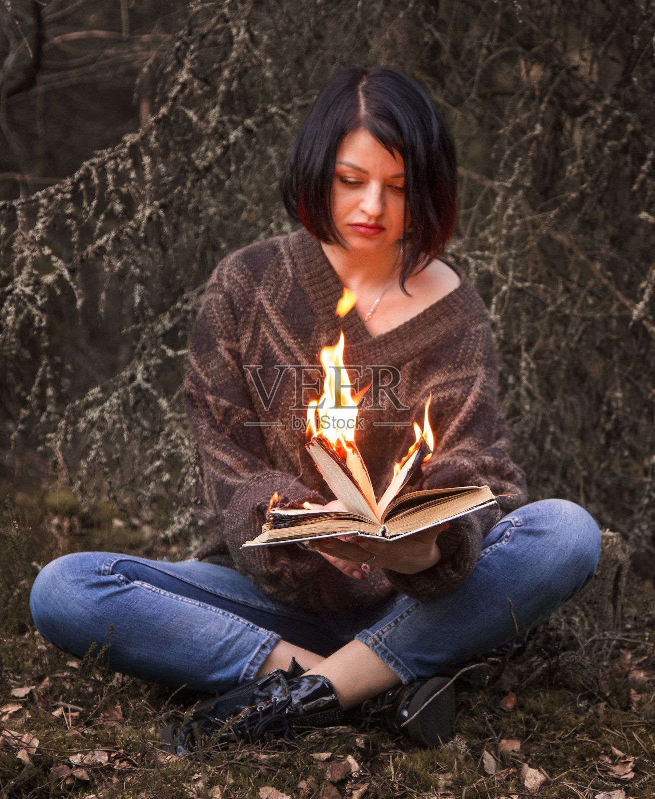 这本书在一个女人的手中被烧掉了照片摄影图片