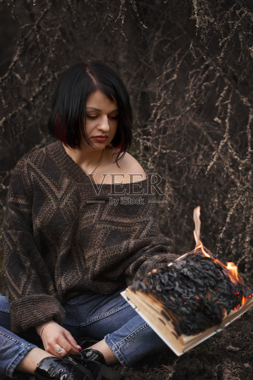 这本书在一个女人的手中被烧掉了照片摄影图片