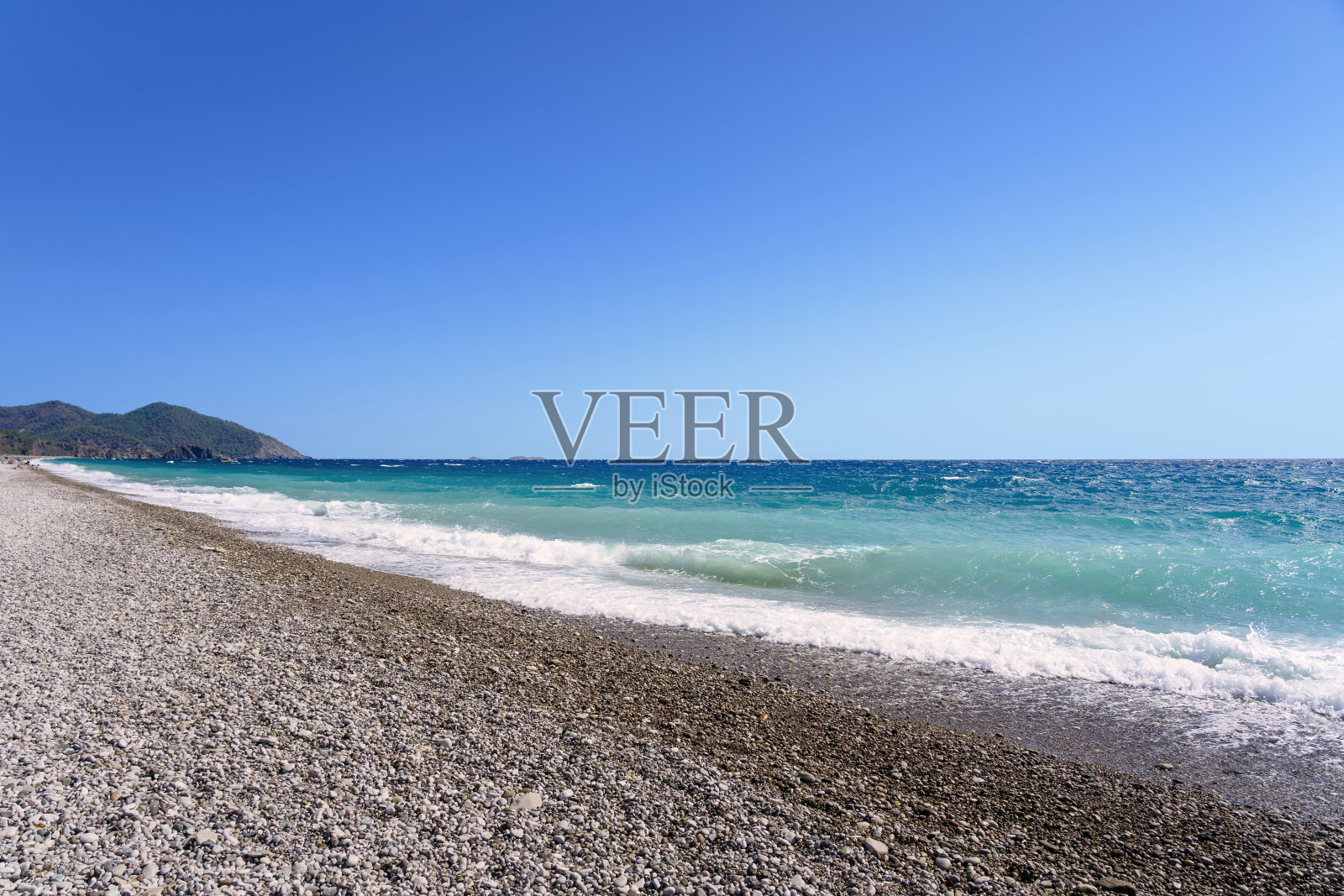 碧蓝色大海和鹅卵石海滩照片摄影图片