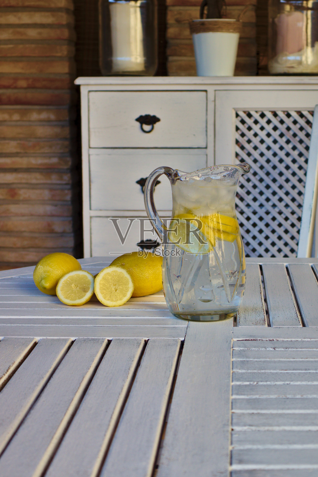 一壶柠檬水和大量冰块，放在白色的桌子上照片摄影图片