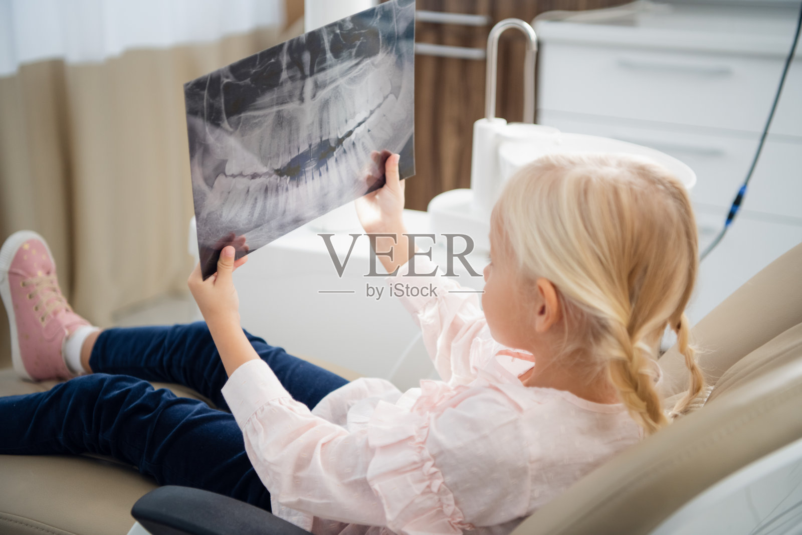 一个小女孩正在检查一个病人牙齿的全景x光片照片摄影图片