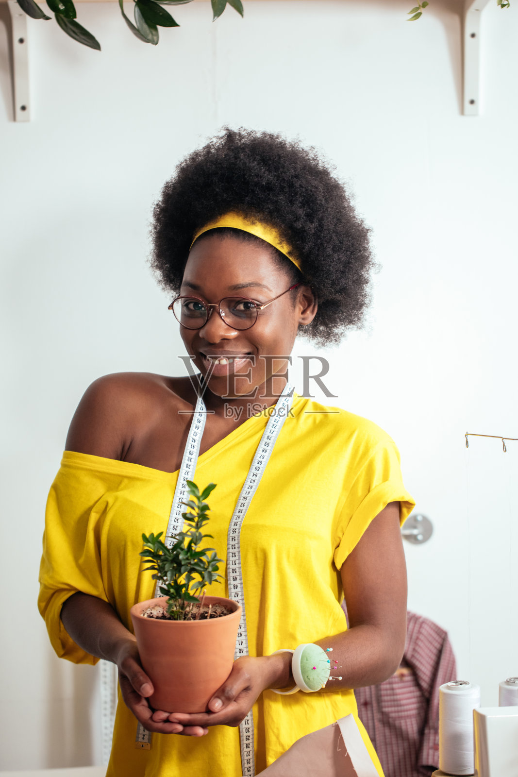 非洲女孩微笑着看着相机手里拿着花盆照片摄影图片