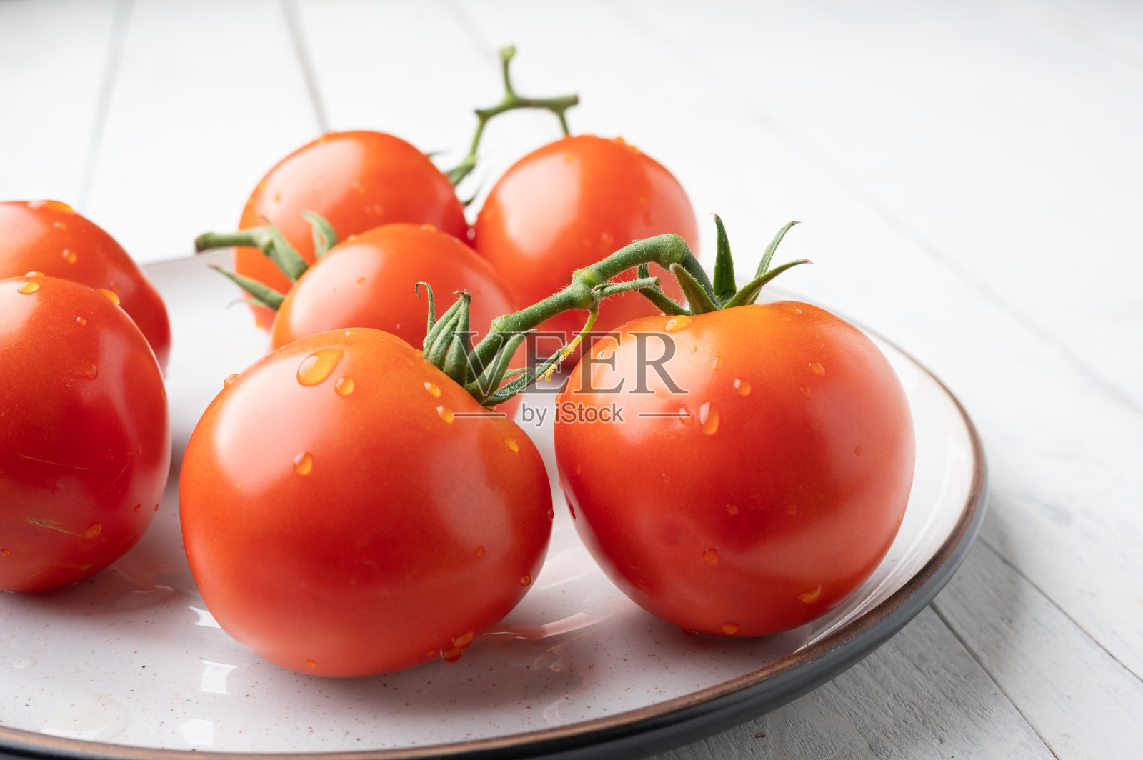 新鲜的西红柿，绿色的茎，白色的背景照片摄影图片