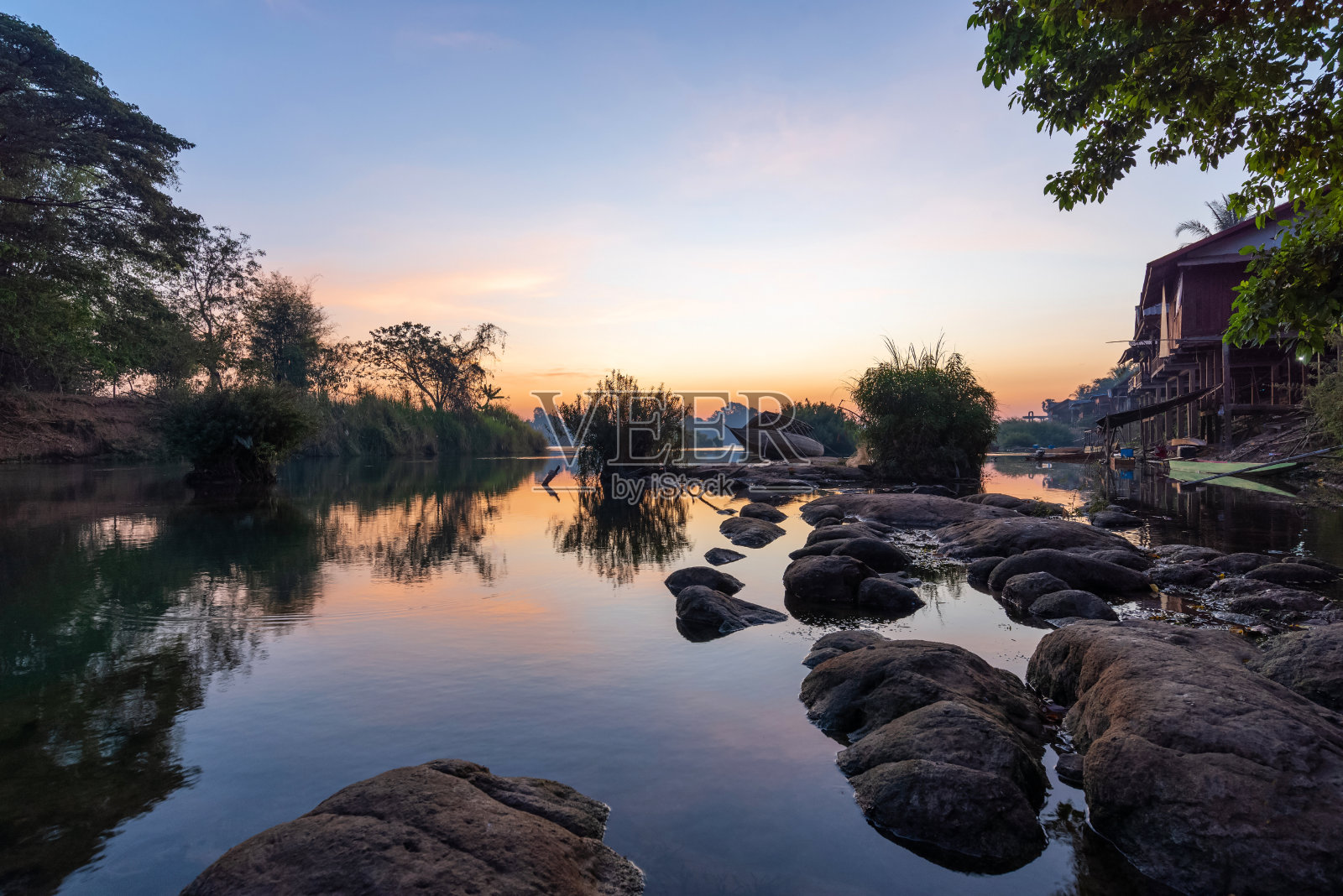 美丽的风景，日出和老木船下降近河从酒店前的登台，在虹吸岛，著名的游客放松的地方，老挝。照片摄影图片