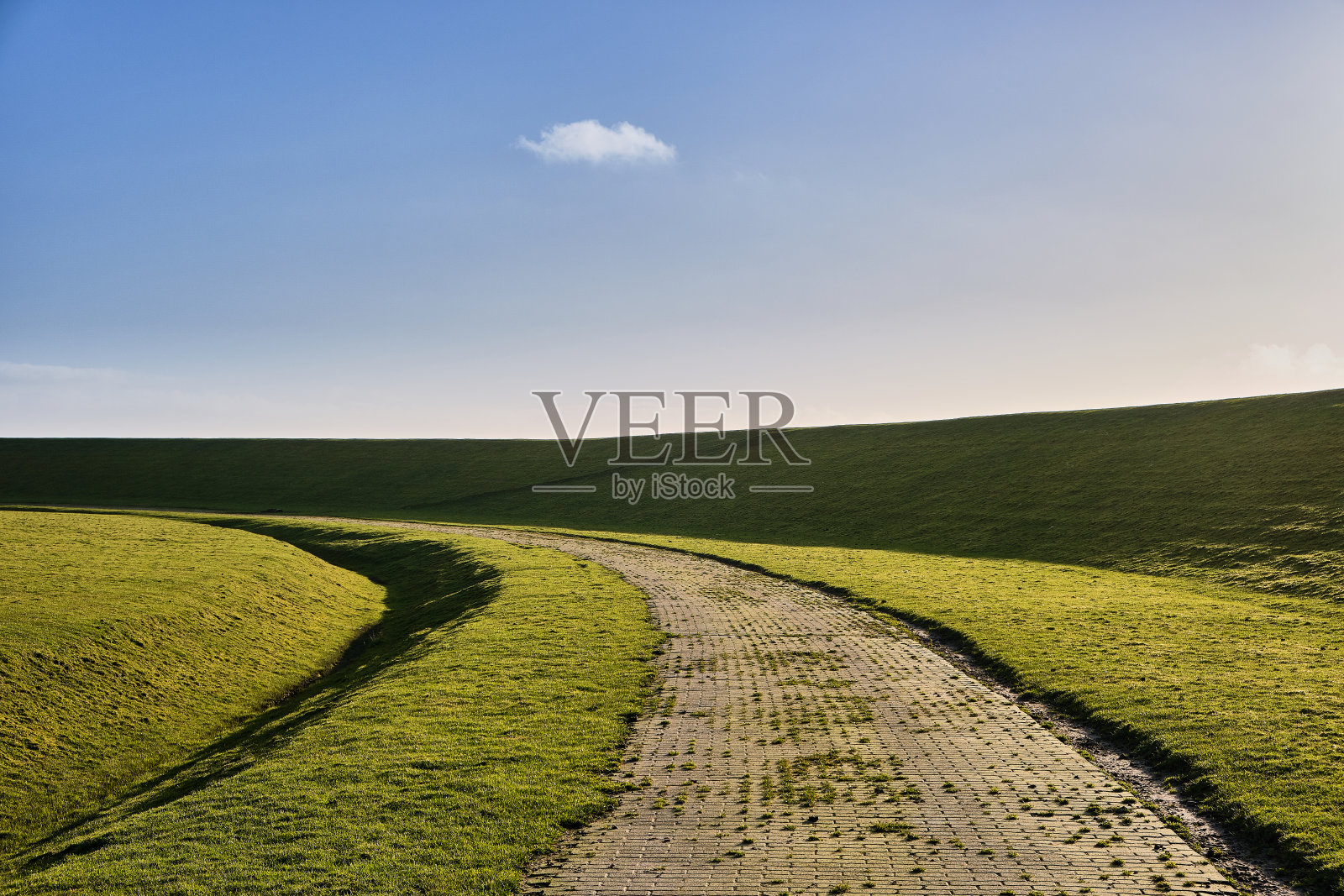 北海岸边堤坝后面弯曲的小路照片摄影图片