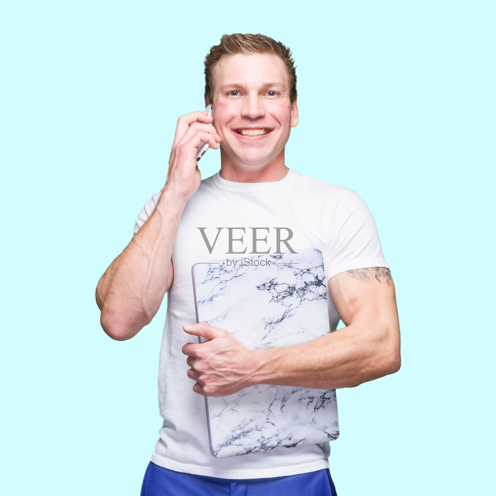 白人年轻男性穿着t恤站在有色背景前使用电脑照片摄影图片