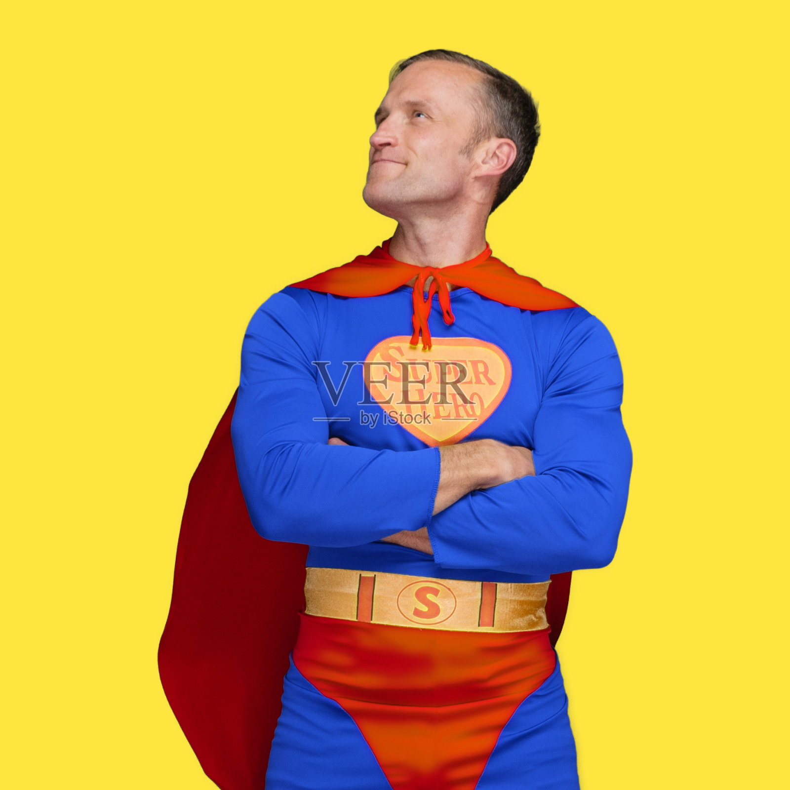 英雄穿着戏服站在黄色背景前照片摄影图片