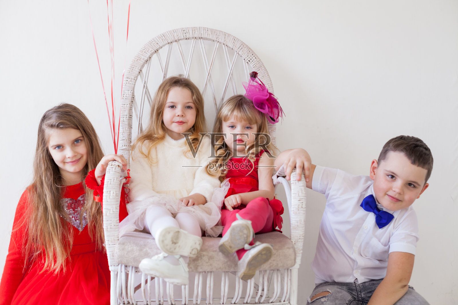 三个小女孩和一个男孩坐在朋友的聚会上照片摄影图片