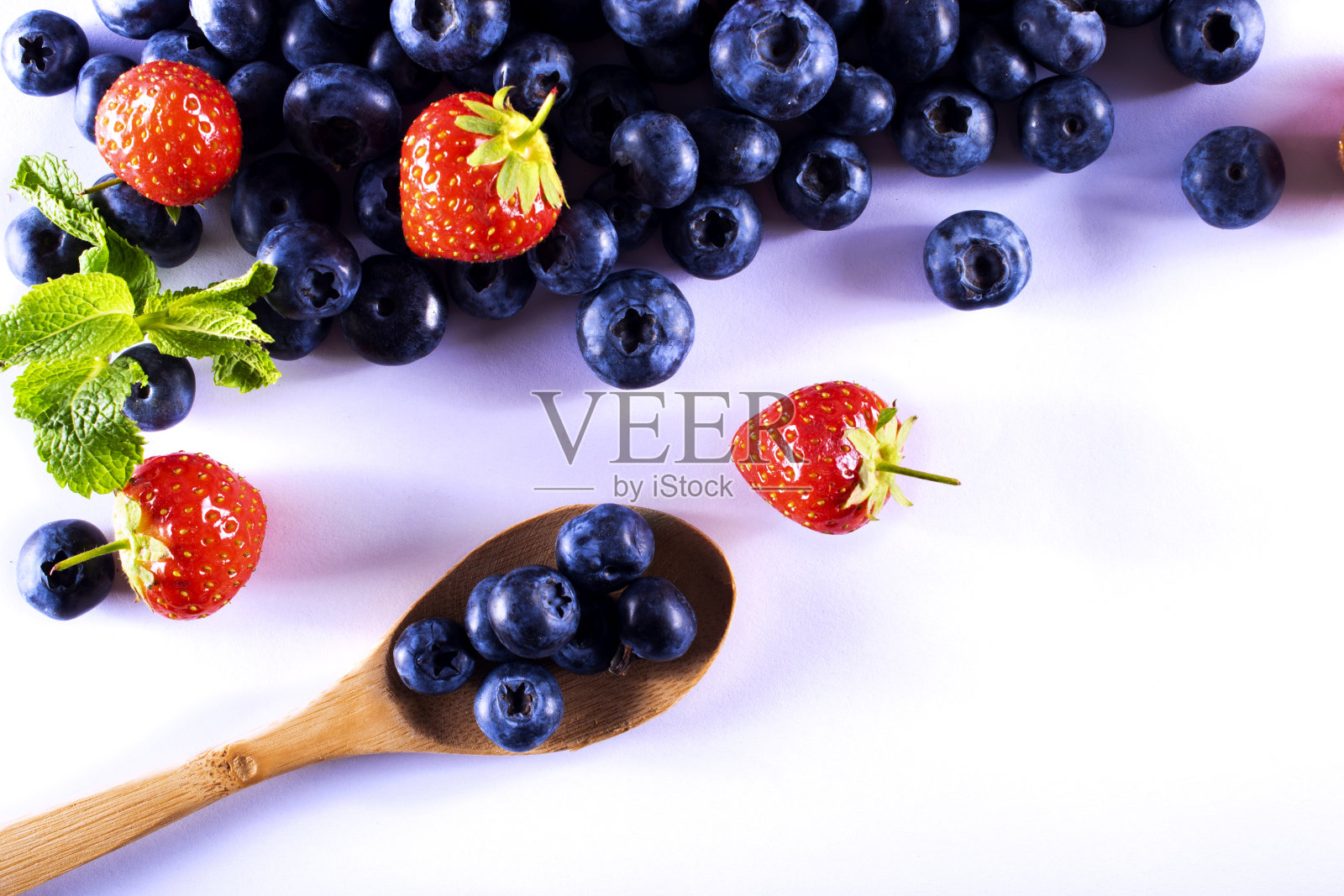 草莓和蓝莓浆果在一个案例孤立的背景。薄荷叶子。新鲜成熟的水果照片摄影图片