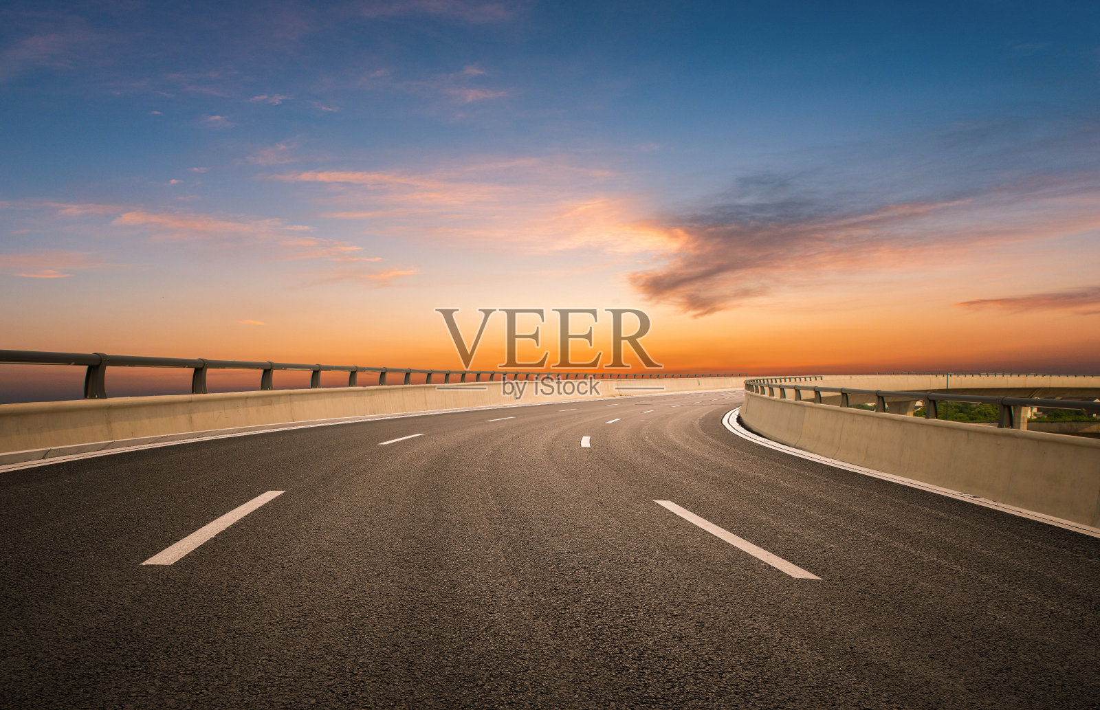 黄昏彩云的背景下，高速公路立交桥弯弯曲曲照片摄影图片