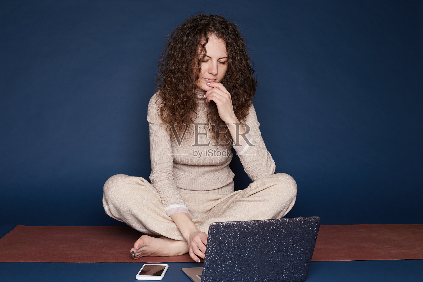 漂亮女人坐在地板上拿着笔记本电脑照片摄影图片