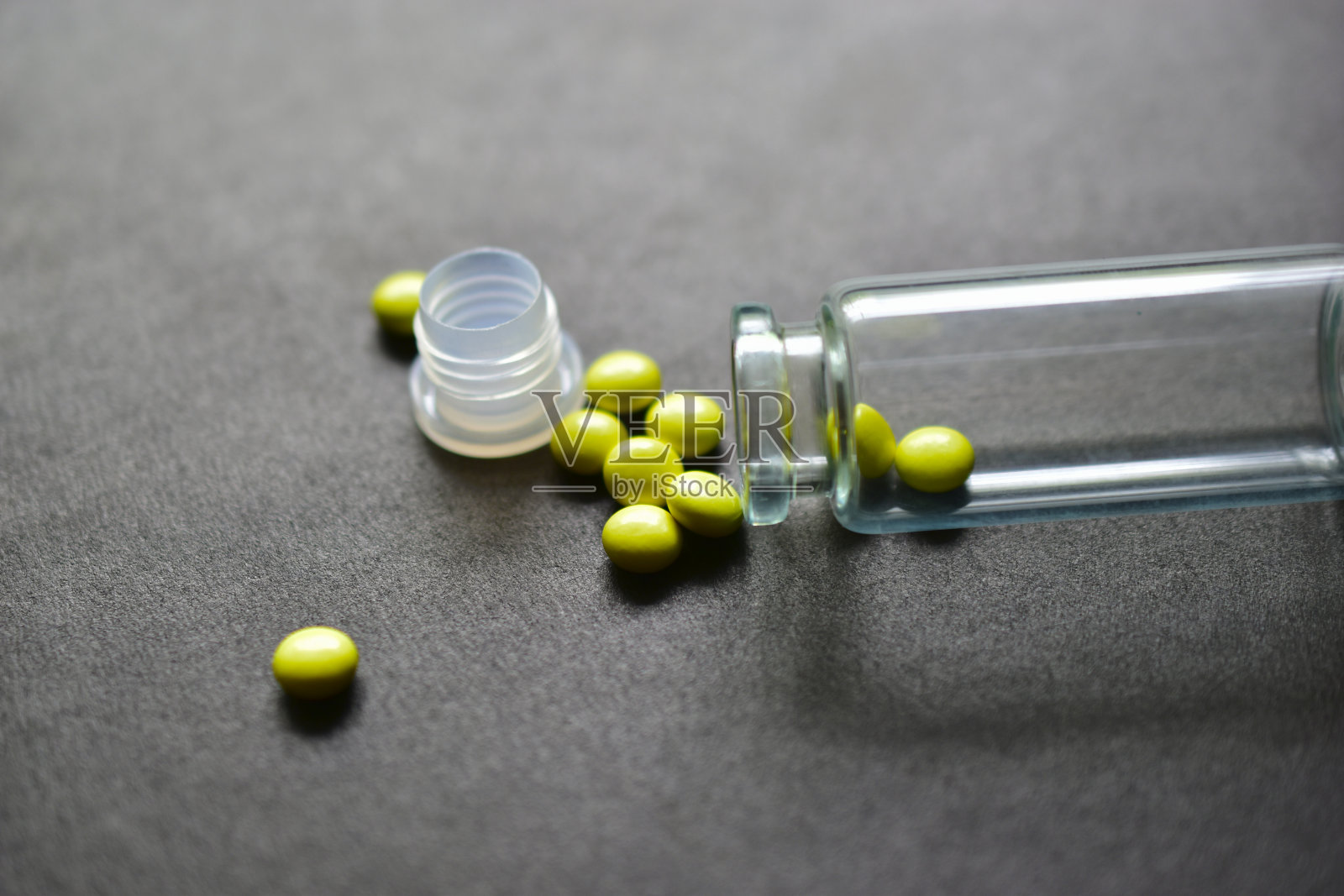 黑色背景上的玻璃罐和黄色药片照片摄影图片