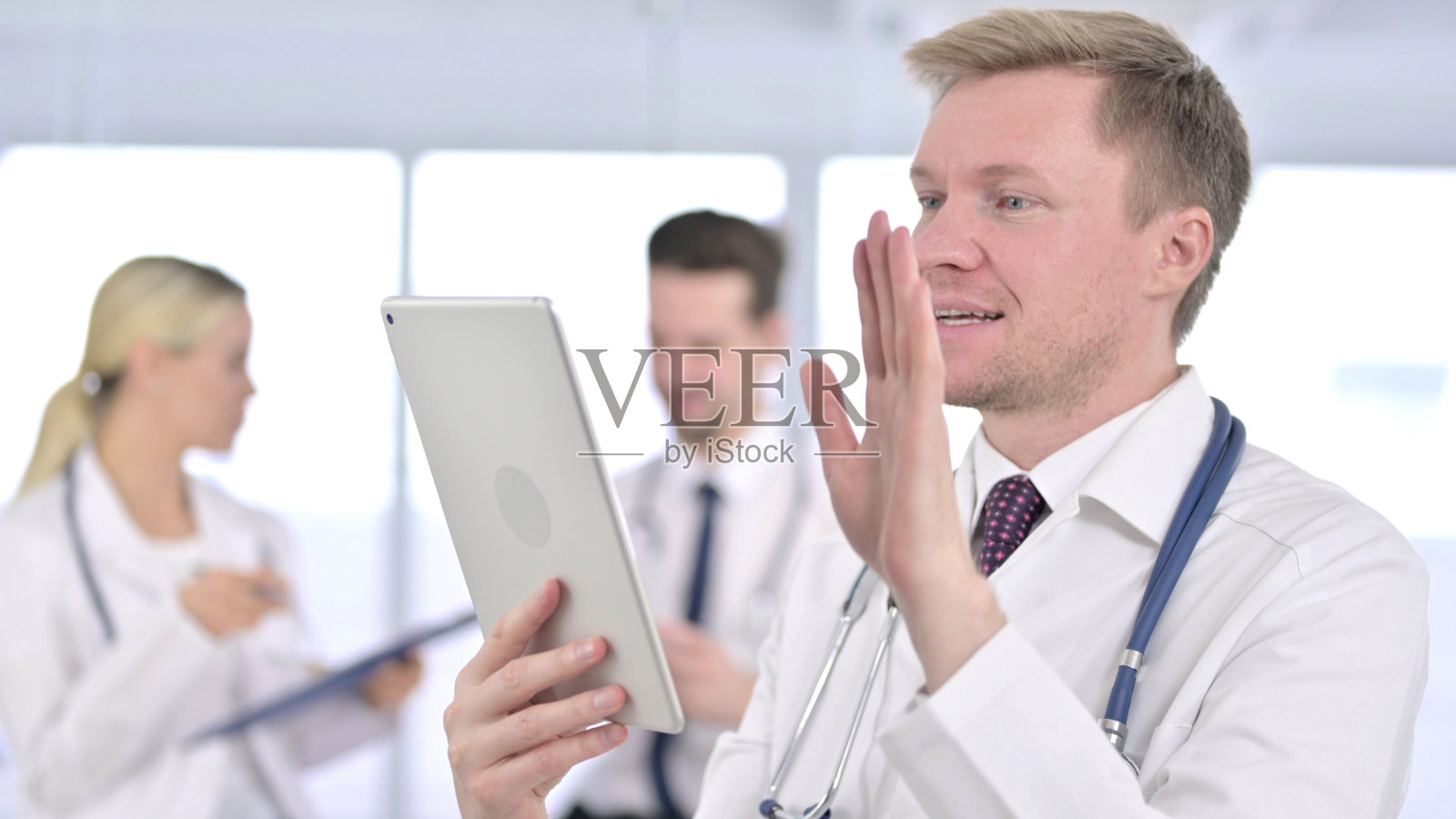 医生在平板电脑上挥手视频聊天照片摄影图片