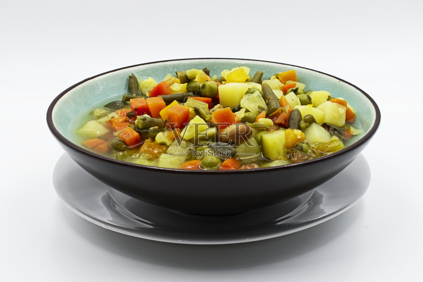 自制的各种蔬菜汤放在盘子里。白色背景照片摄影图片