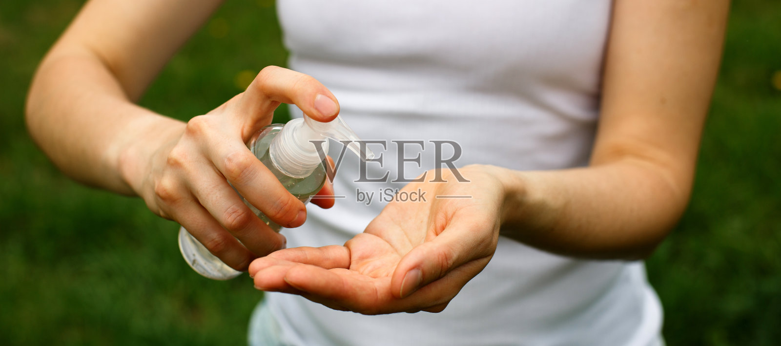 一个妇女在她的手上喷杀菌剂-照顾健康，清洁，保护免受危险的细菌和病毒。照片摄影图片