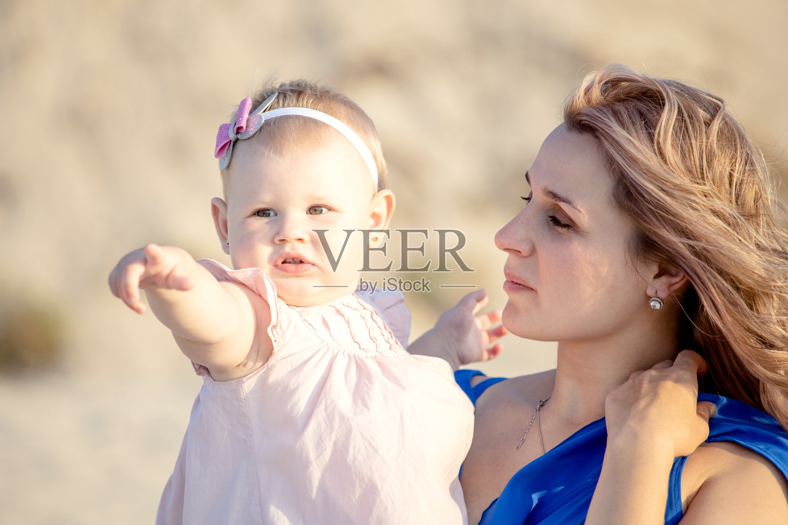 美丽的年轻母亲把小女儿抱在怀里，充满爱意地看着她照片摄影图片