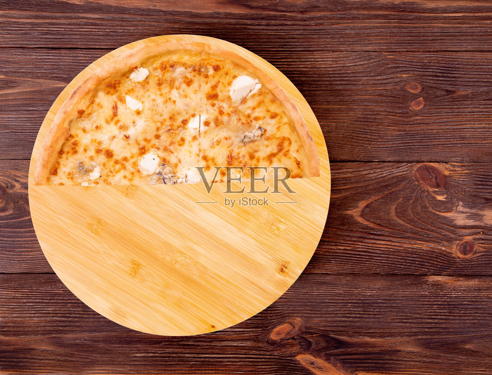 半份披萨，五份芝士放在竹底的木桌上照片摄影图片