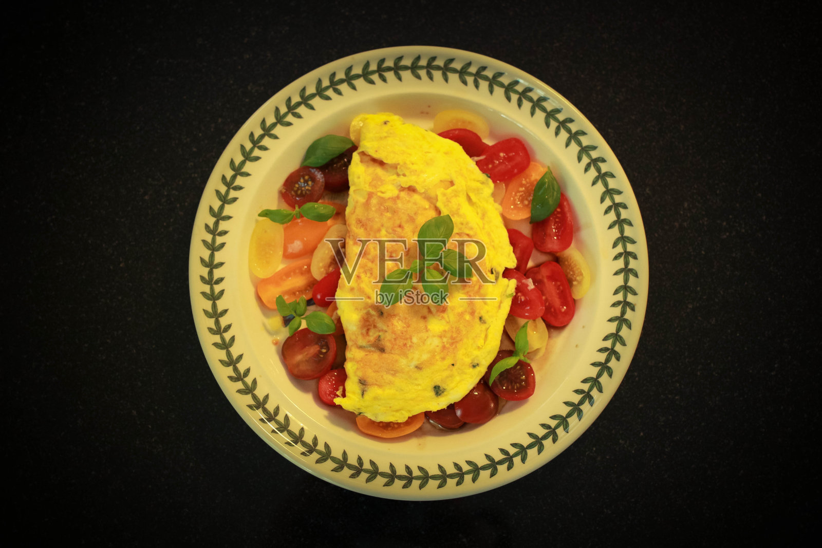 上面有西红柿和罗勒的煎蛋卷。照片摄影图片