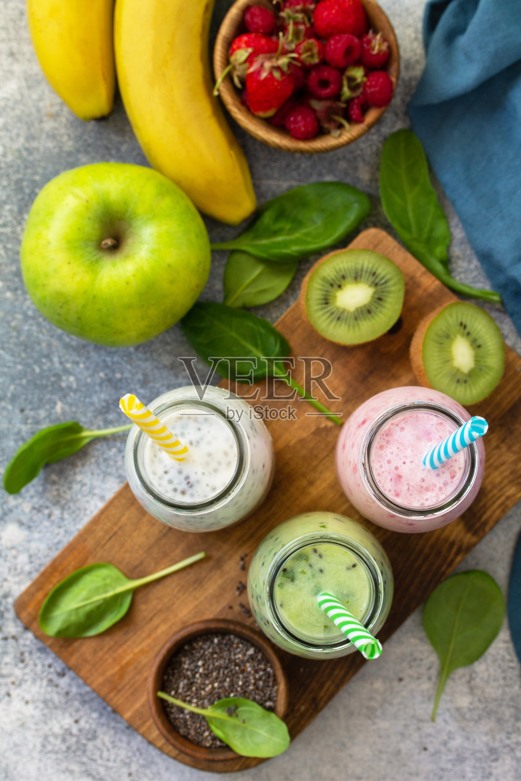 健康饮食的概念。排毒果汁混合。绿色冰沙，蔬菜和水果冰沙在石头混凝土的工作台上。俯视图平铺背景。照片摄影图片