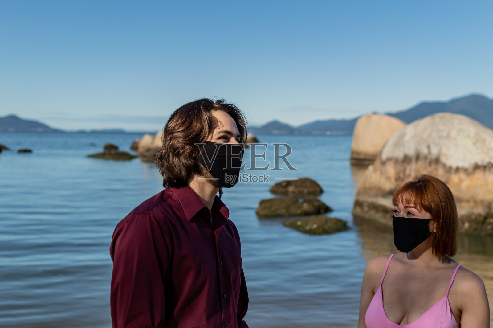 一对年轻的情侣在海滩上散步照片摄影图片