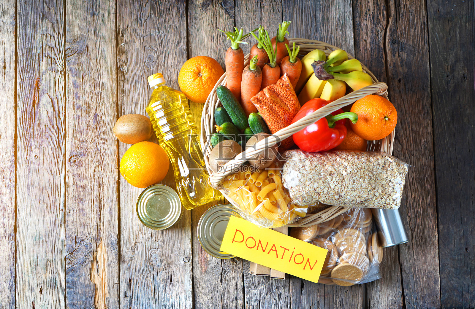 食物捐赠篮与不同的产品和蔬菜在一个篮子与文字捐赠。照片摄影图片